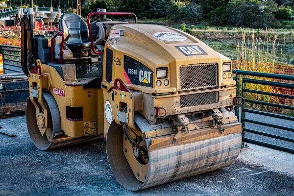 A CAT road roller on an outdoor construction site, perfect for industrial imagery.